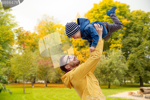 Image of father with son playing and having fun in autumn