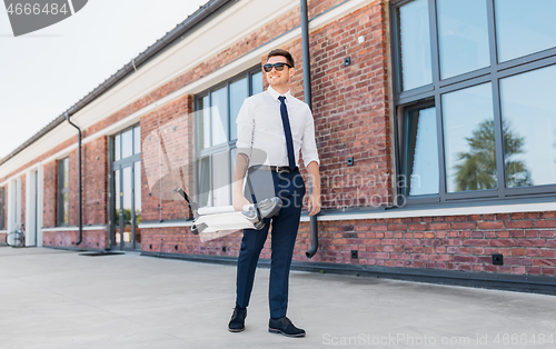 Image of businessman with folding scooter on rooftop