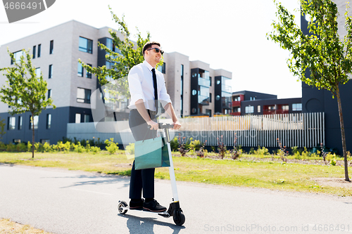 Image of businessman with shopping bag riding scooter