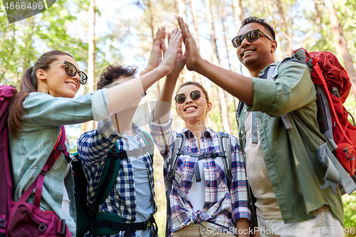 Image of friends with backpacks hiking and making high five