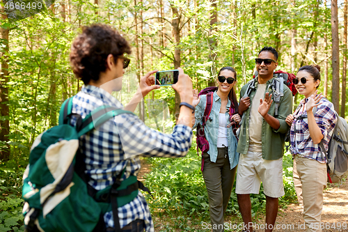 Image of friends with backpacks being photographed on hike