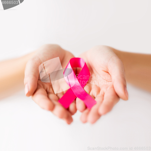 Image of female hands holding pink cancer awareness ribbon