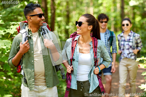 Image of group of friends with backpacks hiking in forest