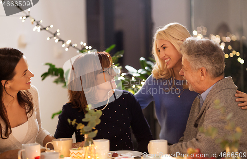 Image of happy family having tea party at home