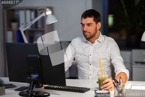 Image of businessman with computer working at night office