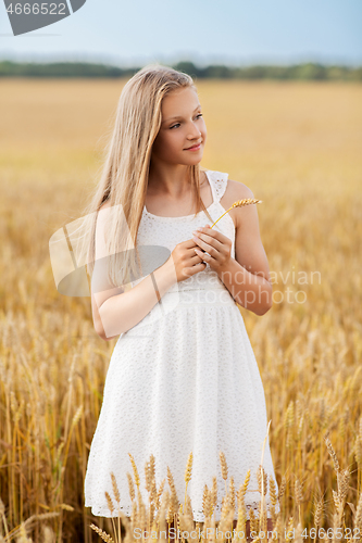 Image of girl with spikelet of wheat on cereal field