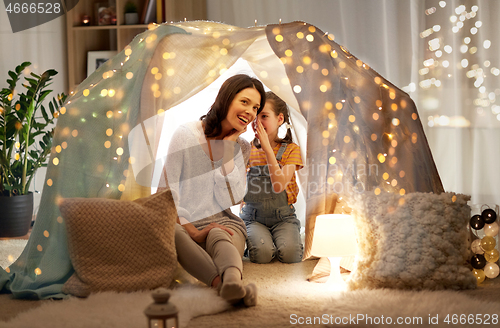 Image of happy family whispering in kids tent at home