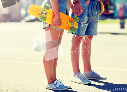 Image of close up of young couple with skateboards in city