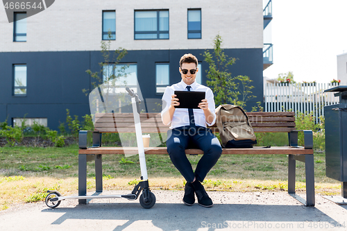 Image of businessman with tablet computer, bag and scooter