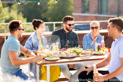 Image of friends having dinner or bbq party on rooftop