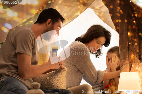 Image of father telling scary stories to his daughter