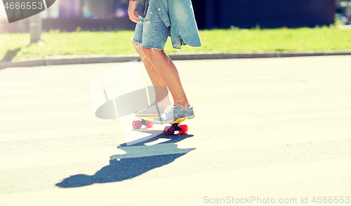 Image of teenage boy on skateboard crossing city crosswalk