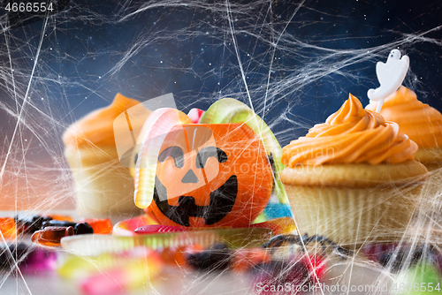 Image of halloween party cupcakes and candies on table