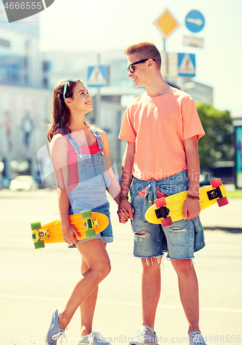 Image of teenage couple with skateboards on city street