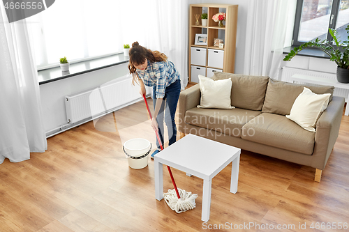 Image of woman or housewife with mop cleaning floor at home