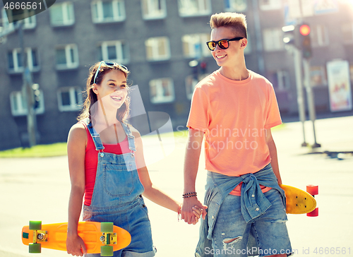 Image of teenage couple with skateboards on city street