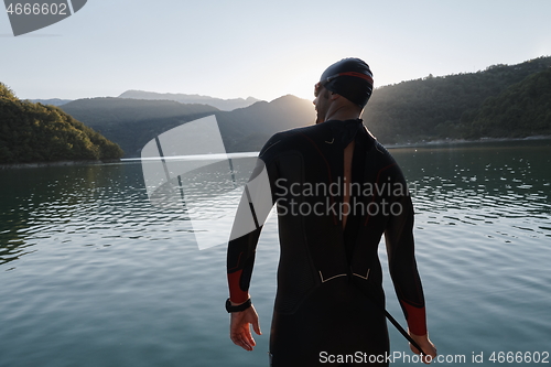 Image of triathlon athlete starting swimming training on lake