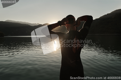 Image of triathlon athlete starting swimming training on lake