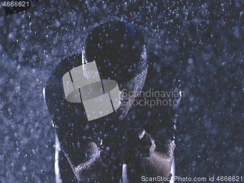 Image of triathlon athlete riding bike on rainy night