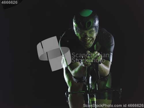 Image of triathlon athlete riding bike at night