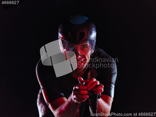 Image of triathlon athlete riding bike at night