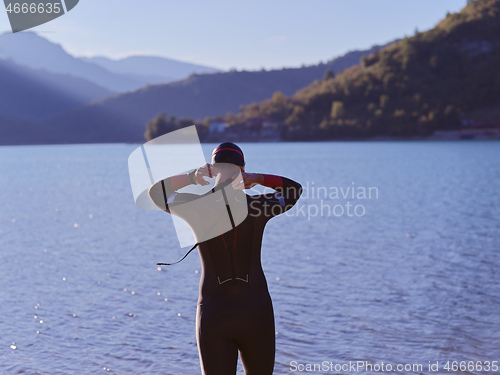 Image of triathlete swimmer portrait wearing wetsuit on training