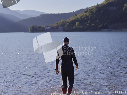 Image of triathlete swimmer portrait wearing wetsuit on training