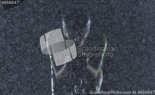 Image of triathlon athlete riding bike on rainy night