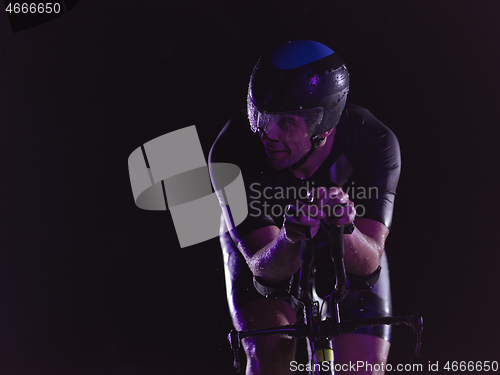 Image of triathlon athlete riding bike at night