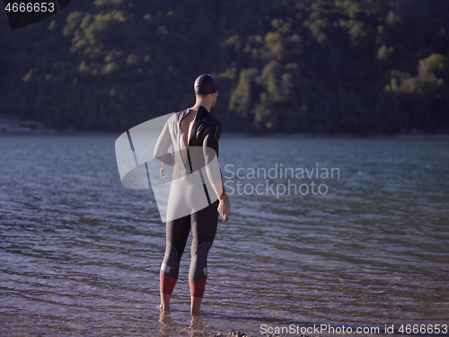 Image of triathlete swimmer portrait wearing wetsuit on training