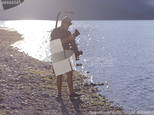 Image of videographer taking action shot of triathlon swimming athlete