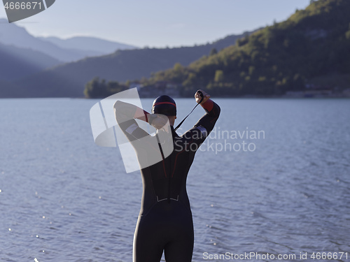 Image of triathlete swimmer portrait wearing wetsuit on training