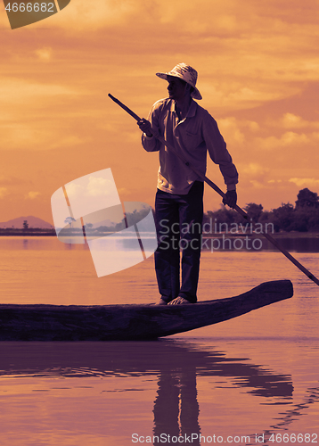 Image of Dak Lak, VIETNAM - JANUARY 6, 2015 - Man pushing a boat with a pole