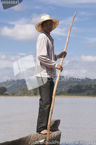 Image of Dak Lak, VIETNAM - JANUARY 6, 2015 - Man pushing a boat with a pole