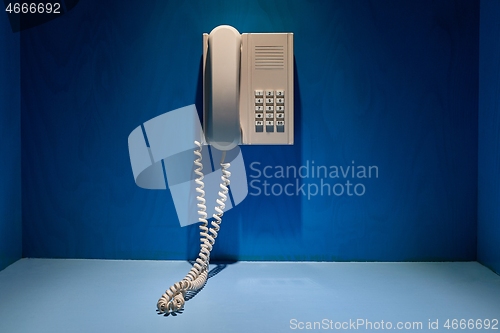 Image of Telefone in harsh spot light on the wall