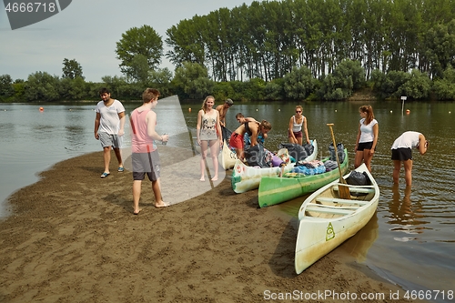 Image of Canoes on the Riverside, People preparing for a trip