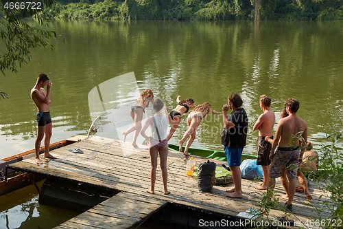 Image of People jumping in the river from a pier