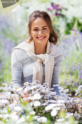 Image of young woman with flowers at summer garden