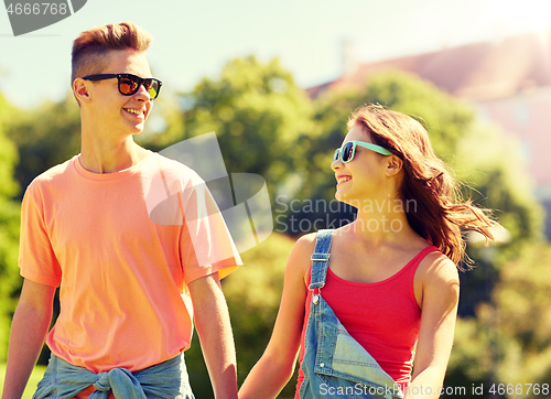 Image of happy teenage couple walking at summer park