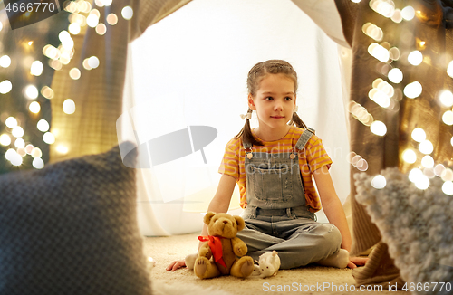 Image of little girl with toys in kids tent at home