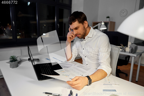 Image of businessman with papers working at night office