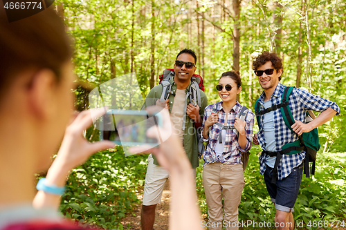 Image of friends with backpacks being photographed on hike