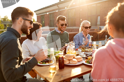 Image of friends having dinner or bbq party on rooftop