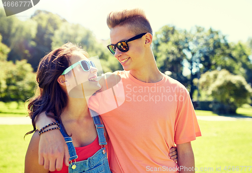 Image of happy teenage couple looking at each other in park