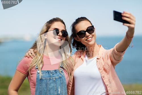 Image of teenage girls or friends taking selfie in summer