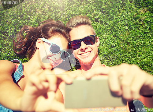 Image of happy couple taking selfie on smartphone at summer