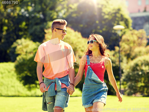 Image of happy teenage couple walking at summer park