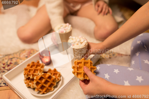 Image of women drinking hot chocolate and eating waffles