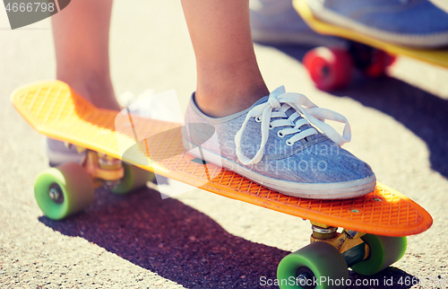 Image of close up of female feet riding short skateboard