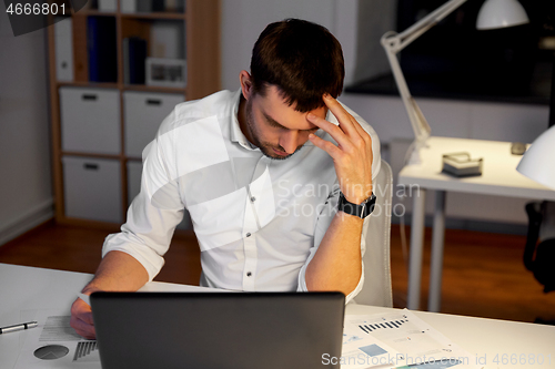 Image of businessman with papers working at night office